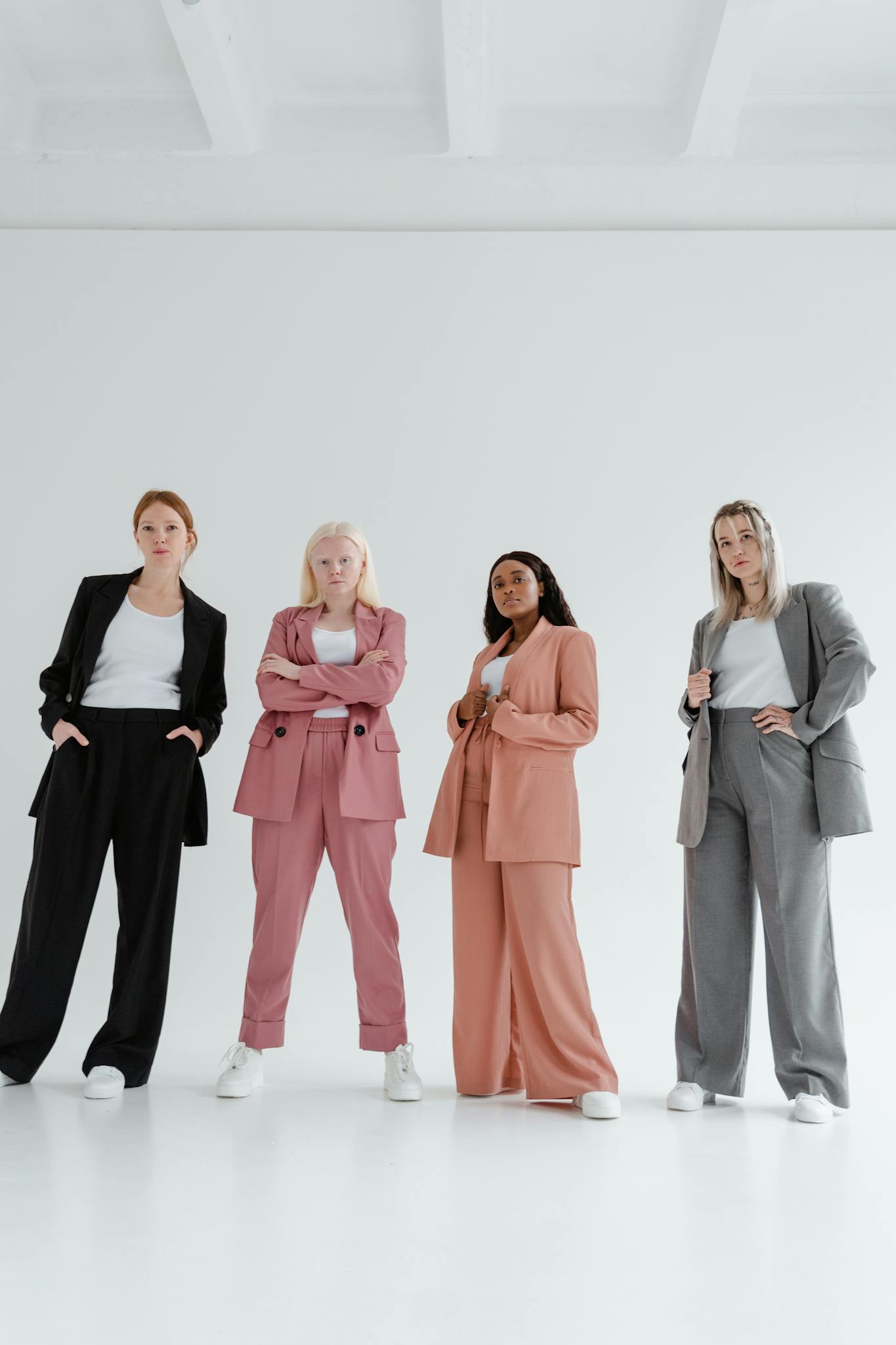 A group of confident businesswomen posing in colorful suits on a white background.