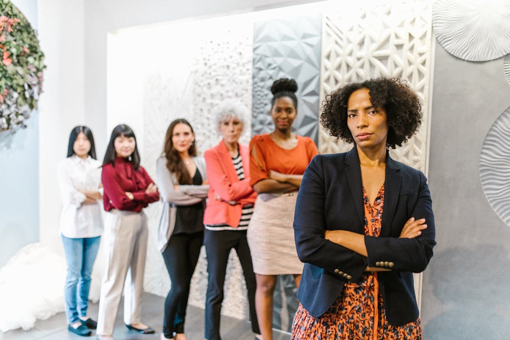 Group of diverse businesswomen standing confidently in modern office setting.
